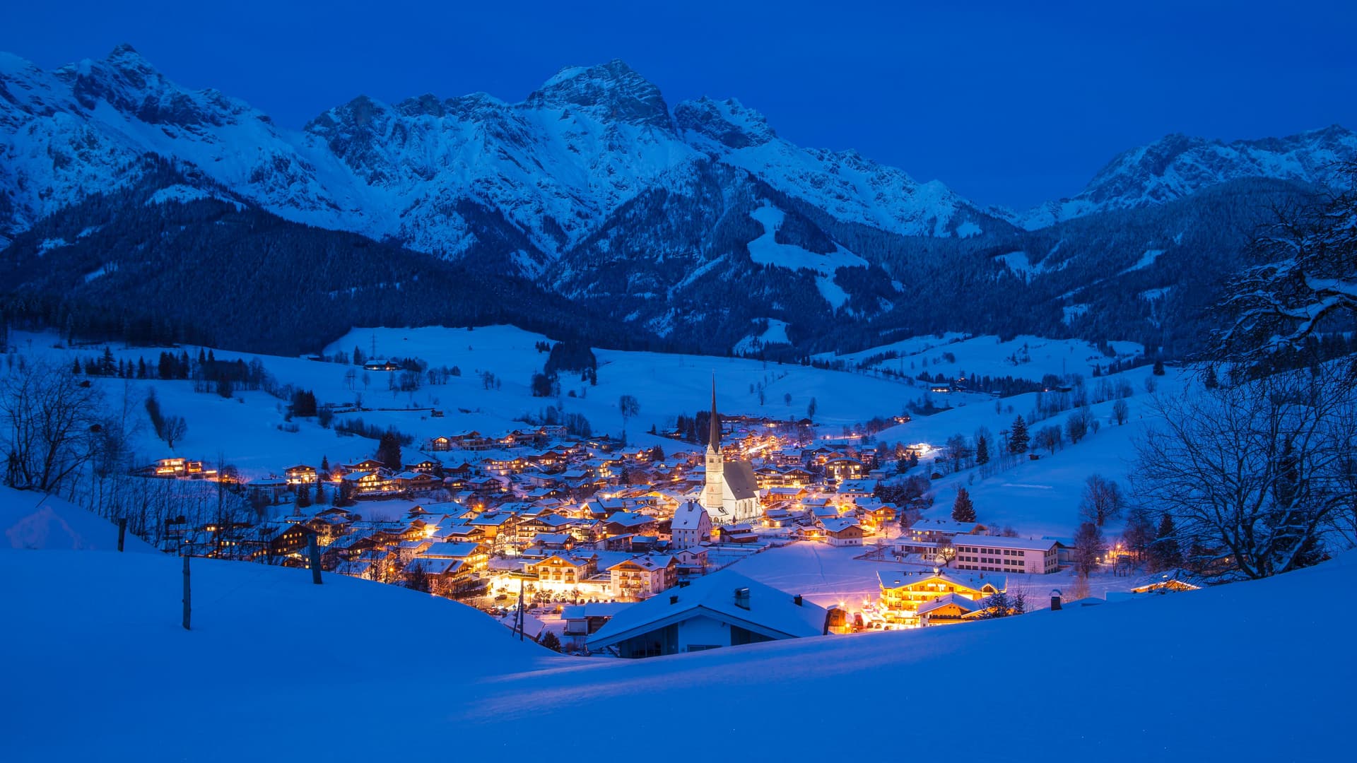 Maria Alm ski resort at night with town lit up and mountains in background